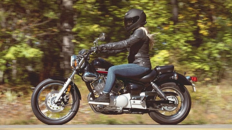 Yamaha V Star 250을 타고 삼림지대 고속도로를 달리는 사람