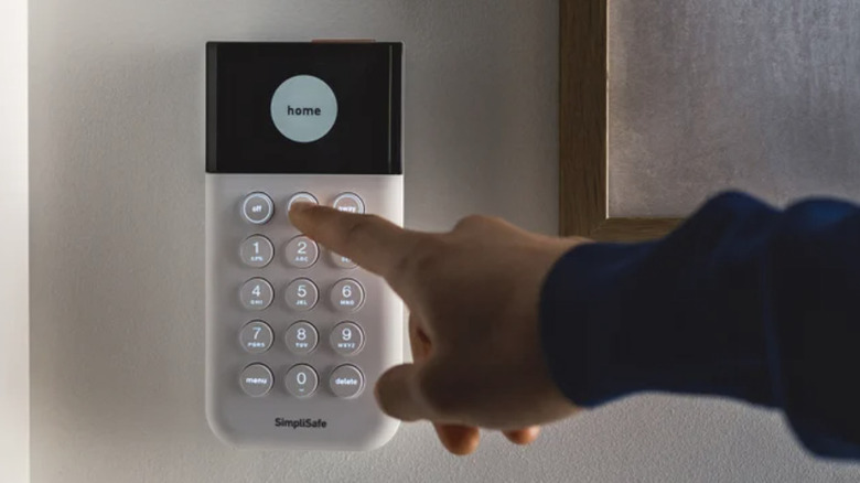 SimpliSafe 보안 시스템의 키패드에 손을 뻗은 클로즈업