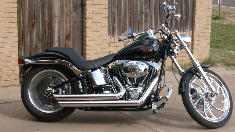 노란색 벽돌 건물 앞에 주차된 Evolution 엔진이 장착된 Harley-Davidson 소프트테일.