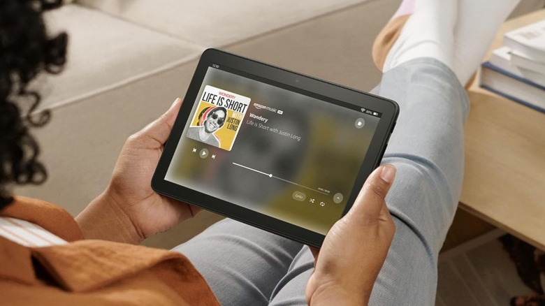 Amazon Fire HD 8 태블릿을 들고 Amazon Music을 검색하는 사람.