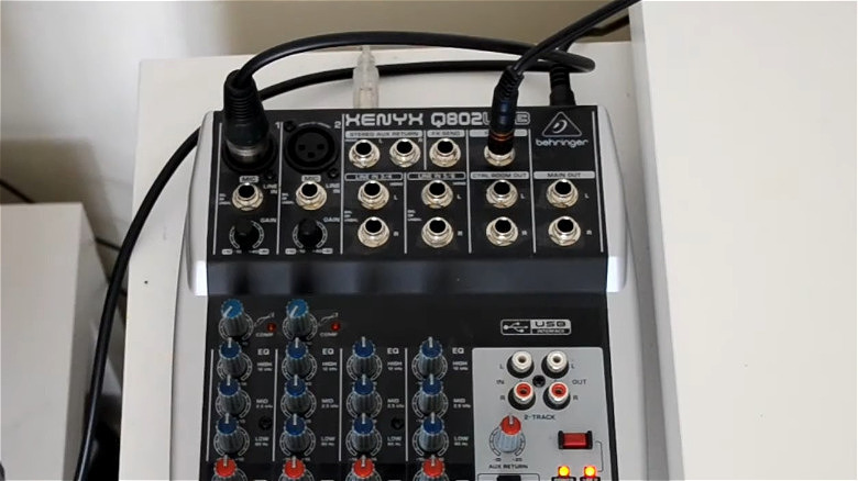 케이블이 삽입된 책상 위에 있는 Behringer Xenyx 802 USB 믹서.