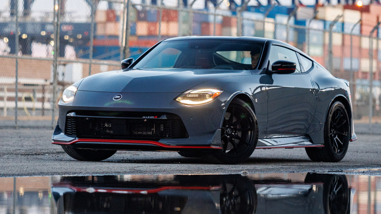 회색 Nissan Z Nismo의 전면 3/4가 항구에 주차되어 있습니다.