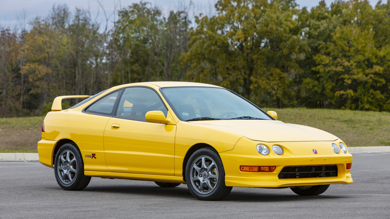 주차장 숲 앞에 주차된 노란색 2001 Acura Integra Type R, 전면 오른쪽 3/4 뷰