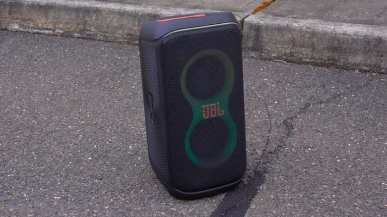 아스팔트 인도 옆에 있는 JBL PartyBox 120 휴대용 파티 스피커