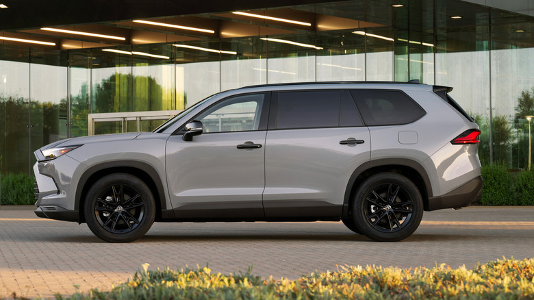 현대적인 사무실 건물 앞에 주차된 회색 2026 Toyota Grand Highlander