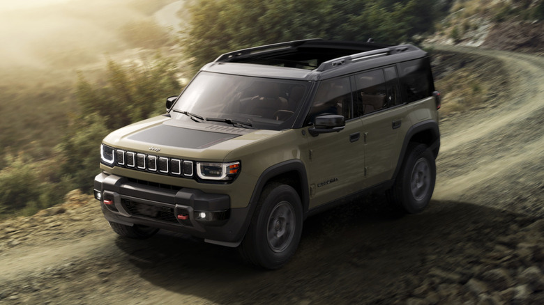 자갈이 깔린 산악 도로를 달리는 녹색 2026 Jeep Recon Moab