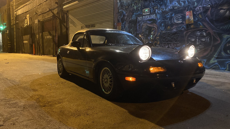밤에 헤드라이트가 켜진 1993년 Mazda Miata