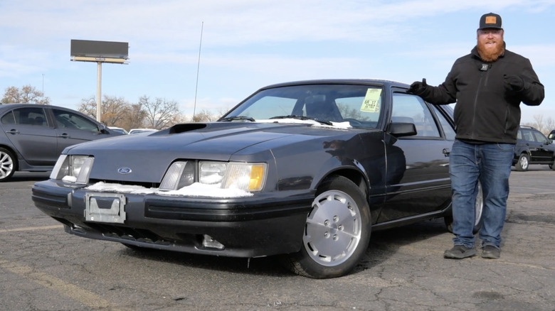 1985년형 Ford Mustang Fox Body SVO 옆에 서 있는 남자