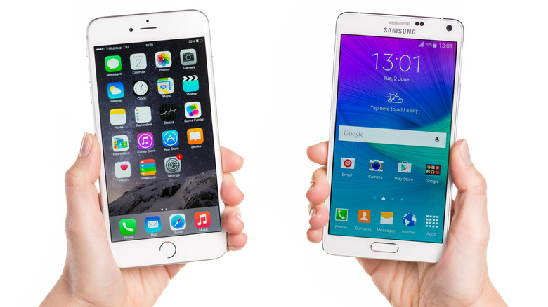 iPhone 6 Plus와 Galaxy Note 4를 들고 있는 사람.