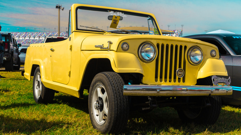 잔디에 주차된 노란색 1968 Jeepster Commando