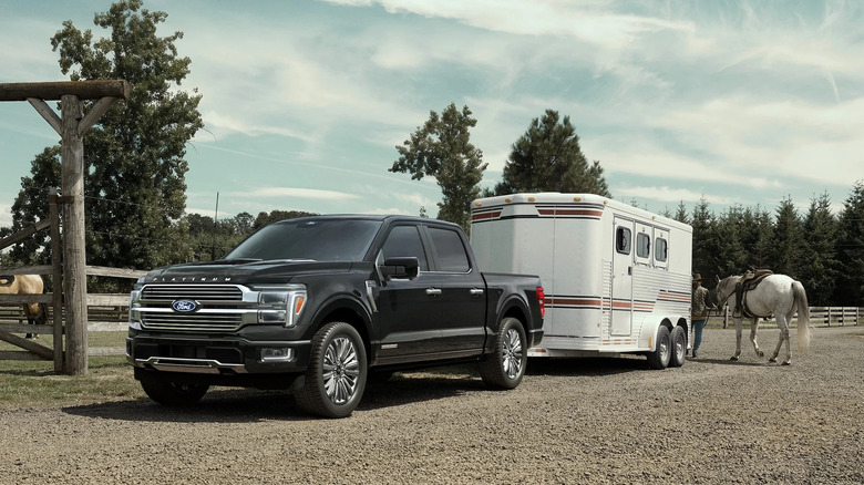 가축 트레일러와 말을 배경으로 한 Ford F-150 PowerBoost 하이브리드, 왼쪽 앞 3/4 뷰