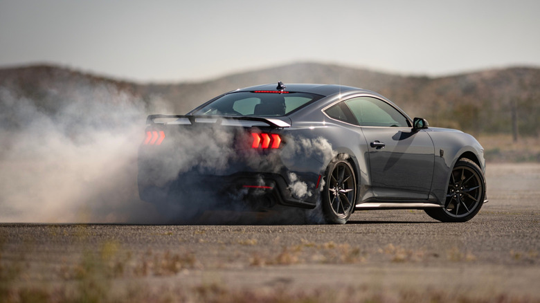 포드 머스탱 다크호스(Ford Mustang Dark Horse)가 타이어를 회전하며 연기를 생성하고 있습니다.
