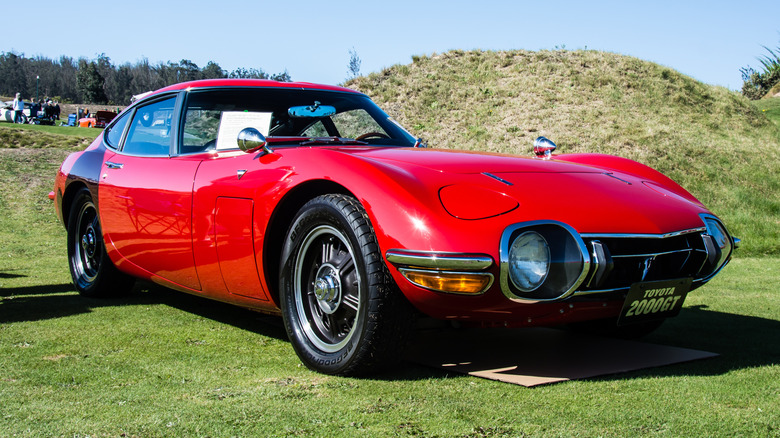 잔디밭에 주차된 빨간색 1967년 Toyota 2000GT.