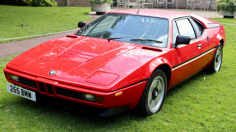 잔디밭에 주차된 빨간색 1980년대 BMW M1.