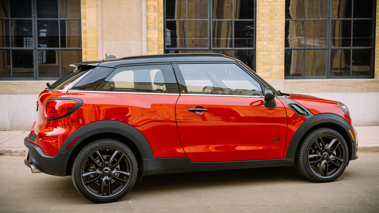 석조 건물 앞에 주차된 새빨간 MINI Paceman