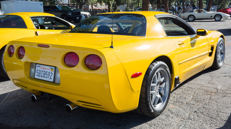 자동차 쇼에 주차된 노란색 C5 Corvette의 후면 3/4 모습.