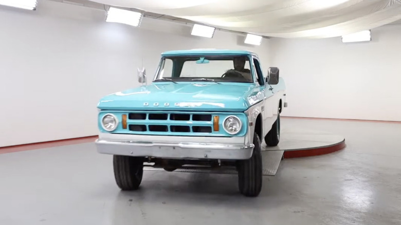 연한 파란색과 흰색의 1969 Dodge W200 Power Wagon 3/4톤 픽업 트럭이 창고 안에 주차되어 있습니다.