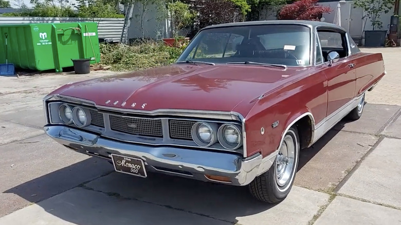 1969년형 Dodge Monaco 500 하드톱 쿠페가 햇볕이 잘 드는 진입로에 짙은 금속성 빨간색 페인트로 마감된 이곳입니다.