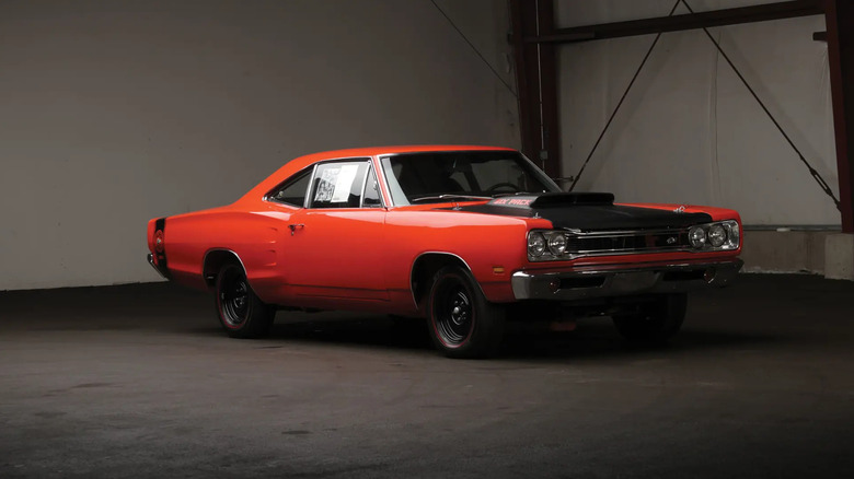 암실 내부에 A12 성능 패키지가 옵션으로 포함된 주황색 및 검정색 1969.5 Dodge Super Bee.