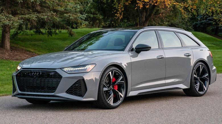 나무 앞에 주차된 회색 Audi RS6 Avant의 전면 3/4 모습.