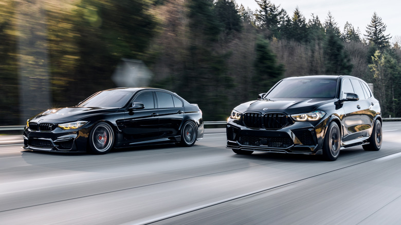 검정색 BMW X5 SUV가 검정색 BMW M3 옆에서 운전되었습니다.