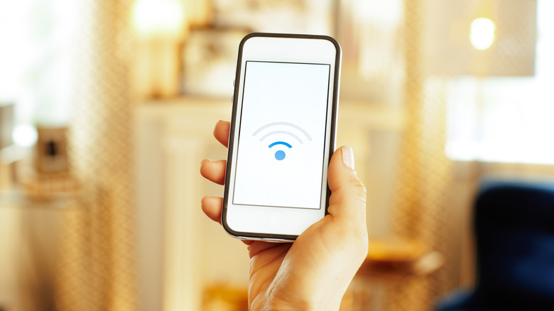 Wi-Fi 연결 상태가 좋지 않은 이미지를 보여주는 스마트폰을 들고 있는 사람의 손