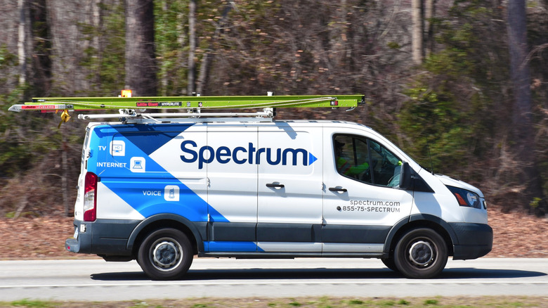숲 근처 도로를 주행하는 Spectrum 밴