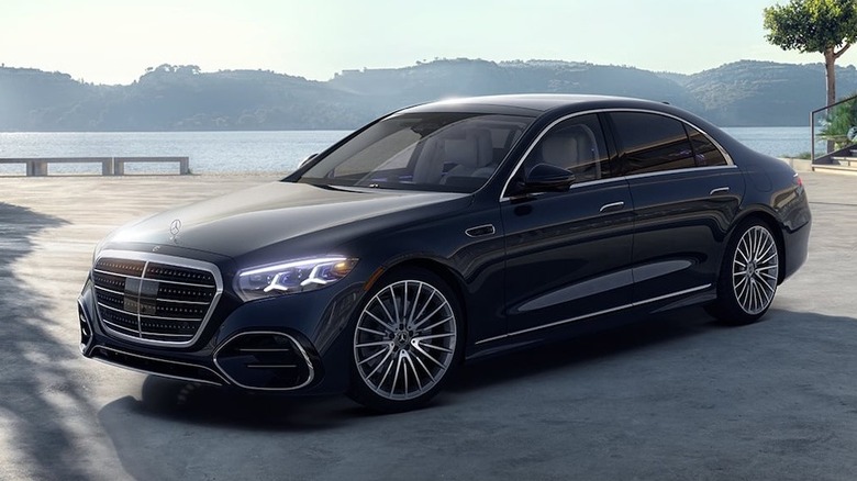 호수 앞에 주차된 검정색 2027 Mercedes-Benz S 500 4Matic