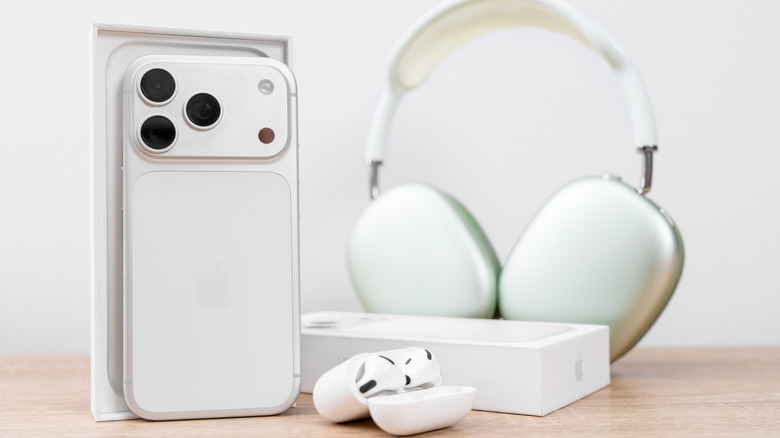 나무 테이블 위에 놓인 iPhone 17 Pro, AirPods Max 2, AirPods 3 사진