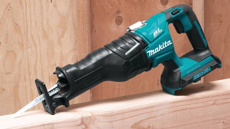 나무 위에 놓인 Makita 36V LXT Brushless Recipro Saw.