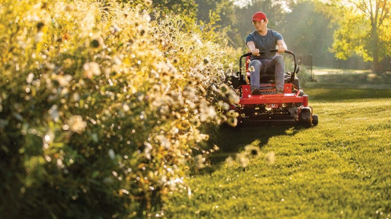 Troy-Bilt 제로턴 모어로 잔디를 깎고 있는 사람