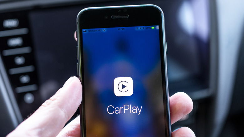 CarPlay가 표시된 iPhone을 들고 있는 사람