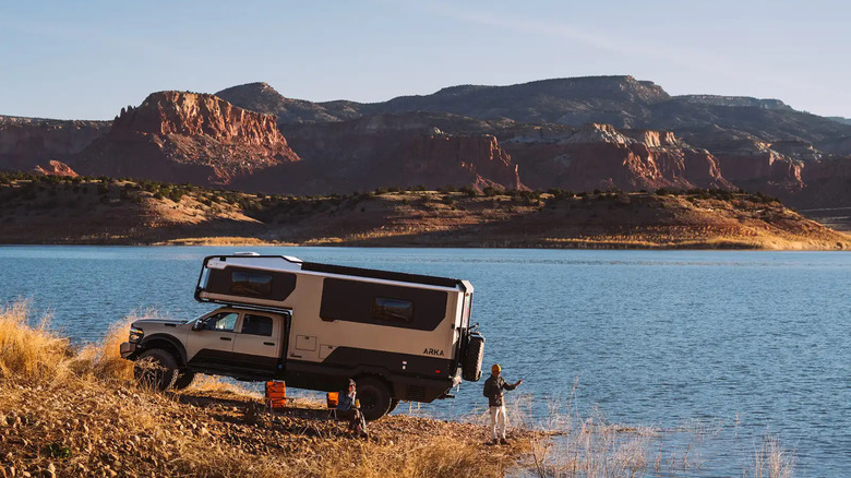 낚시하는 사람이 있는 Winnebago ARKA 주차된 호숫가, 왼쪽 모습