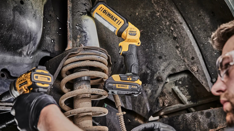 작업자가 작업을 조명하기 위해 사용하는 DeWalt 20V MAX* LED 휴대용 구역 조명.