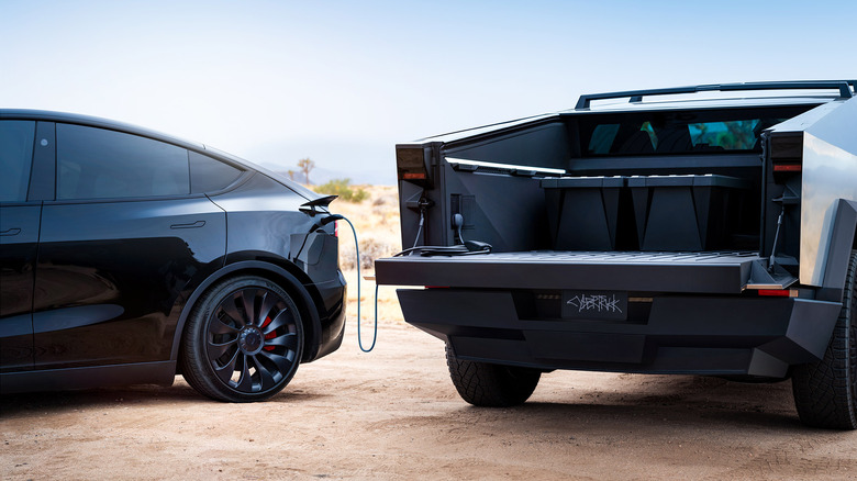 검은색 Tesla Model Y를 충전하는 Tesla Cybertruck의 후면 모습.