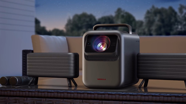 야외 테이블에 추가 스피커가 있는 Anker Nebula X1 프로젝터
