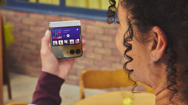 음악이 재생되는 접힌 2026 Motorola Razr을 들고 있는 사람