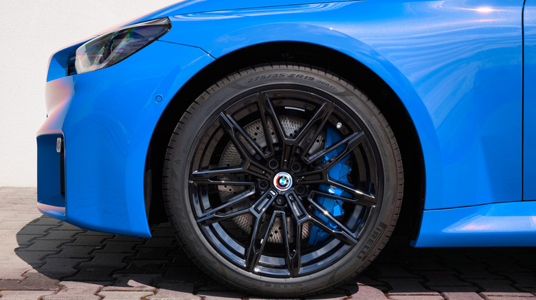 파란색 BMW M2 쿠페의 앞바퀴 클로즈업.