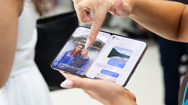 열린 iPhone Duo 휴대폰을 들고 있는 여성