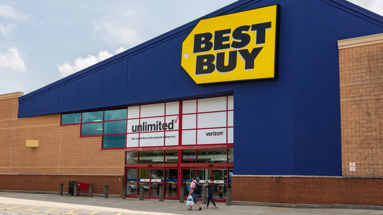 Best Buy 매장 밖으로 걸어가는 사람들.