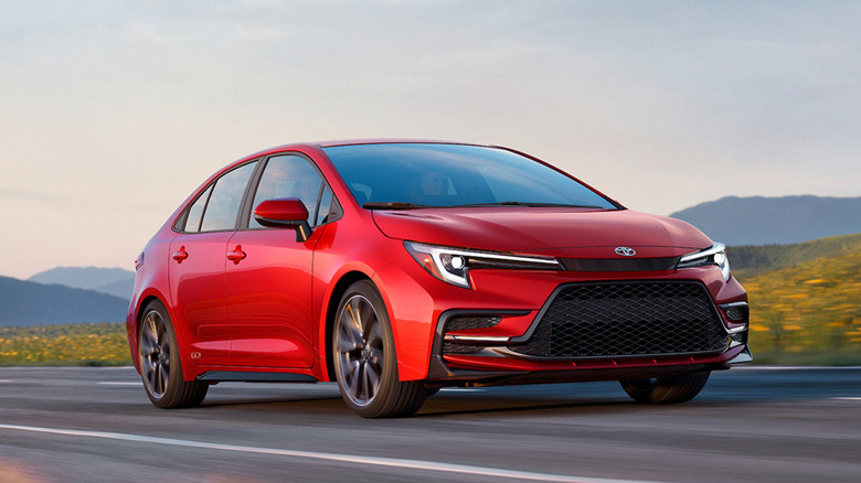 시골길을 달리는 빨간색 2027 Toyota Corolla