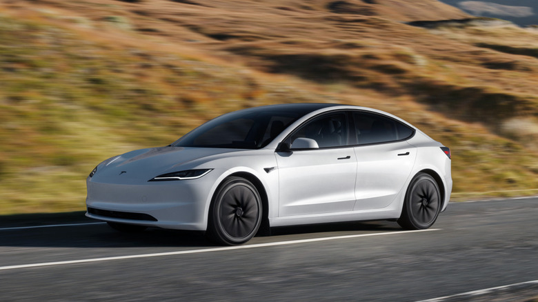 산악 도로를 달리는 흰색 Tesla Model 3