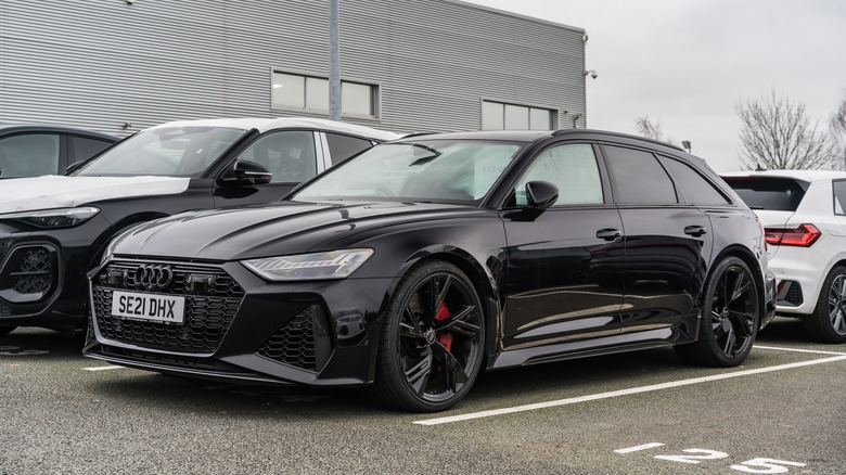 검은색 Audi RS6 Performance Avant가 다른 Audi 차량 근처에 주차되어 있습니다.