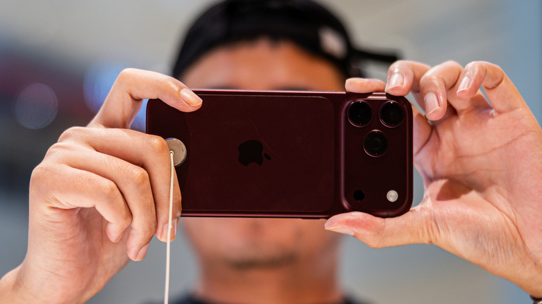 사진을 찍기 위해 iPhone 18 Pro를 들고 있는 사람.
