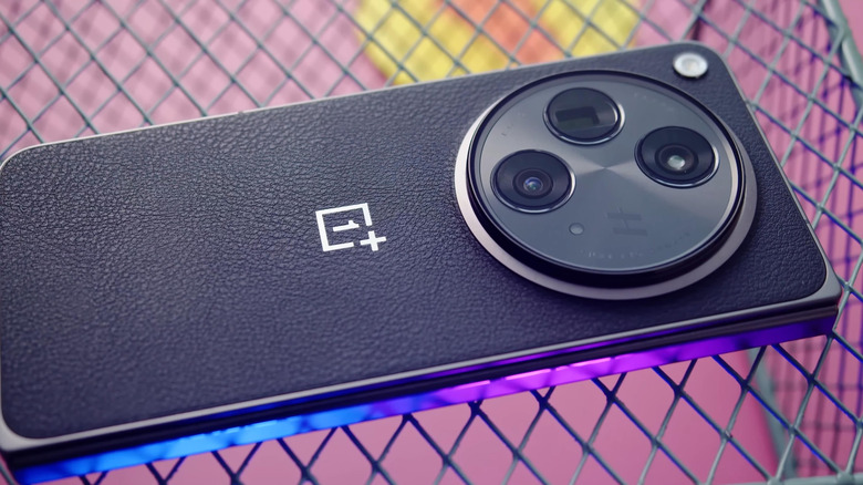 유선 표면에 놓인 OnePlus 15 스마트폰의 근접 촬영