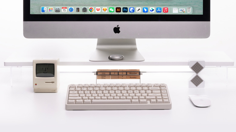 iMac 앞에 있는 NuPhy Node75 기계식 키보드와 그 옆에 독특한 달력과 Apple 마우스가 있는 모습