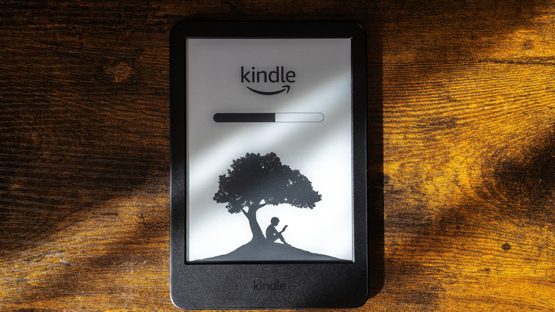 로딩 화면이 있는 나무 테이블 위에 놓인 Kindle