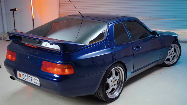 차고의 스튜디오 조명 아래에서 뒤에서 촬영한 희귀한 파란색 Porsche 968 Turbo S.