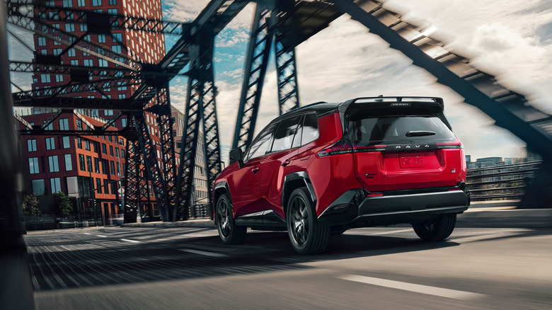 다리 위에서 주행하는 빨간색 Toyota RAV4 GR Sport의 후면 3/4 뷰.