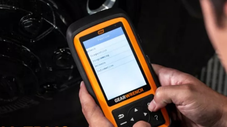 자동차에서 Gearwrench TPSM 도구를 사용하는 사람.